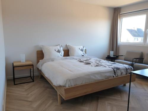 een slaapkamer met een groot bed en een raam bij Snooze in Oostende