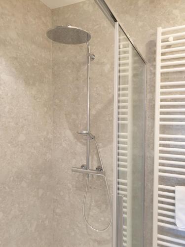 a shower with a glass door in a bathroom at Snooze in Ostend