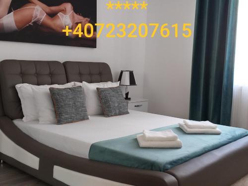 a bedroom with a bed with two towels on it at Luxury-Apartment Ultracentral in Câmpulung Moldovenesc