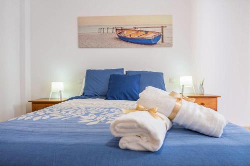 1 dormitorio con 1 cama con sábanas azules y 1 barco en Apartamento Las Playitas, en Tuineje