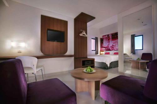 a living room with a bed and a living room with a couch at favehotel PGC Cililitan in Jakarta