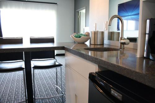 a kitchen with a granite counter top and a sink at The Wallhouse Hotel, an Ascend Collection Hotel in Walnut Creek