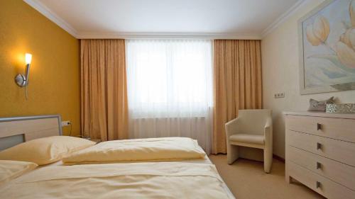 a bedroom with two beds and a dresser and a window at Appartement Koller in Pertisau