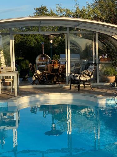 a patio with a pool and a table and chairs at Herrgårdsflygel mitt i Sörmland in Malmköping