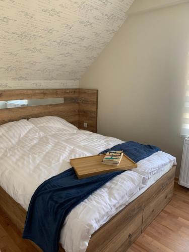 ein Bett mit einem hölzernen Tablett darüber in der Unterkunft VIP House 1 in Vrnjačka Banja