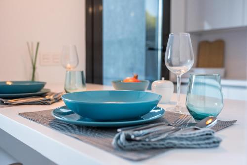 a table with a blue bowl and two wine glasses at Casa Aire de Mar, modern house with private pool, overlooking Baviera golf, within walking distance of beach in Vélez-Málaga