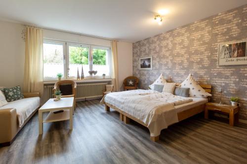 een slaapkamer met een bed en een bakstenen muur bij Ferienwohnung Nattkamp für Familien und Radbegeisterte in Oberhausen