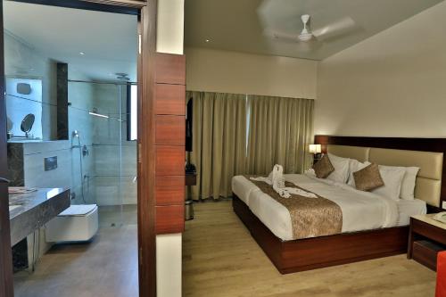 ウダイプールにあるSeasons Park Resortのベッドとバスルーム付きのホテルルームです。