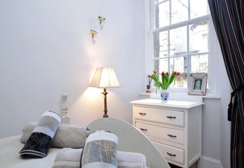 een woonkamer met een bank, een stoel en een raam bij ALTIDO Chic apt in the Royal Mile Tower in Edinburgh