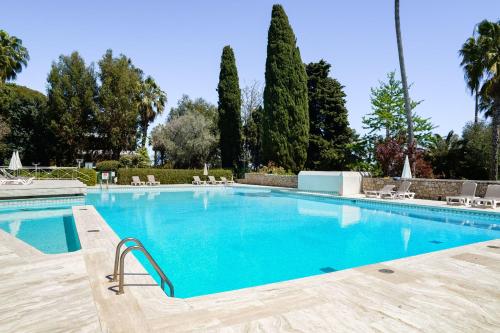 une grande piscine avec de l'eau bleue dans l'établissement Côte d’Azur Sea View Tennis Beach Access, à Vallauris