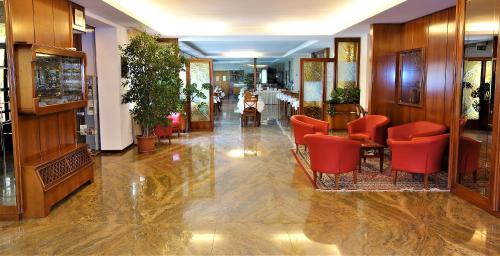 a lobby with red chairs and tables in a building at Euromotel Croce Bianca in Verona