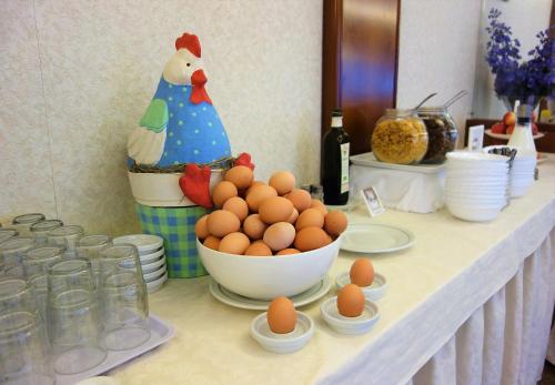 a buffet with eggs and a chicken and a table with glasses at Euromotel Croce Bianca in Verona