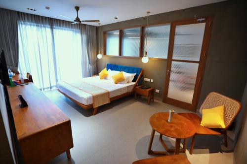 a hotel room with a bed and a table and chairs at E.05 City Inn in Alwaye