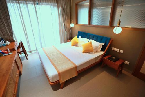 a bedroom with a large bed with yellow pillows at E.05 City Inn in Alwaye