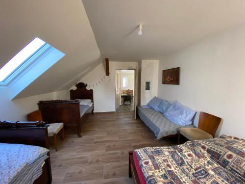 - une chambre avec 2 lits, un canapé et une fenêtre dans l'établissement Chalupa U Berušek, à Oskava
