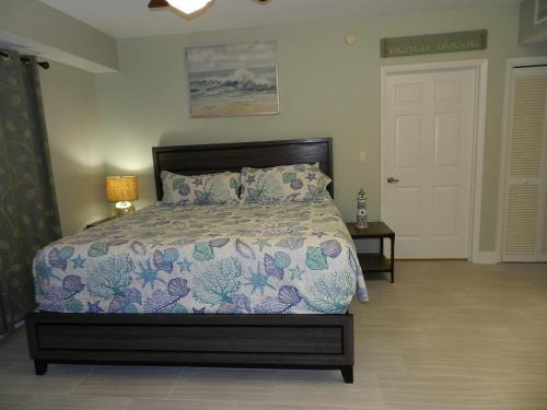 a bedroom with a bed with a floral bedspread at 24th Floor 3 BR Resort Condo Direct Oceanfront Wyndham Ocean Walk Resort Daytona Beach 2425 in Daytona Beach