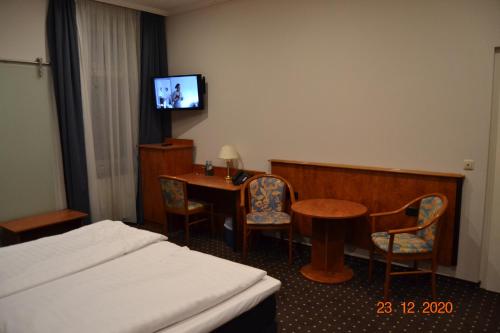 a hotel room with a bed and a table and a tv at Hotel Zeil in Frankfurt/Main