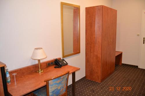 a room with a desk with a telephone and a mirror at Hotel Zeil in Frankfurt/Main