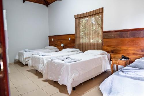 a group of three beds in a room at IPÊ Florido Parque Hotel in Paracatu