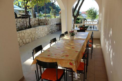 a long table in a room with chairs around it at Apartments Josip 2830 in Rab