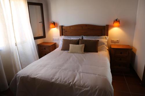 1 dormitorio con 1 cama blanca grande y 2 almohadas en Casa Rural Mas dels Fumeros en Useras