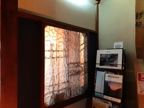 a glass door with a glass wall in a room at Guest House FUTARENO in Yokohama
