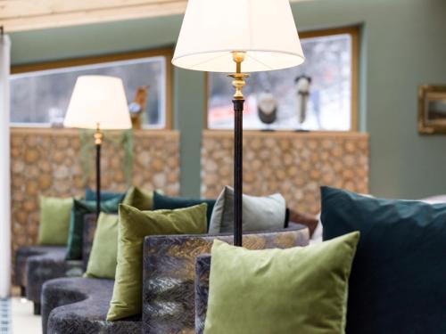 a living room with couches and two lamps and pillows at Alpin Family Resort Seetal in Kaltenbach