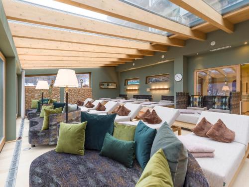 a living room with a lot of couches and pillows at Alpin Family Resort Seetal in Kaltenbach