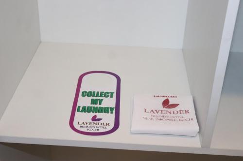 a shelf with a sign that reads collect my laundry and a book at Lavender Infopark Kochi in Kakkanad