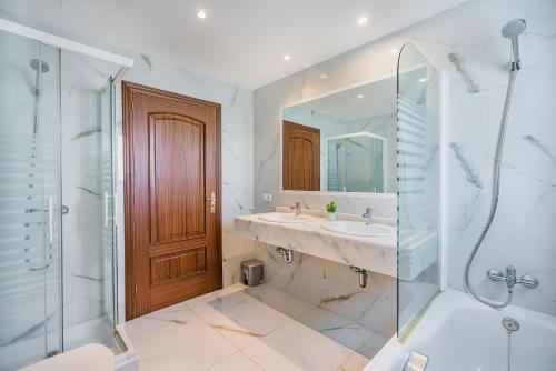 a bathroom with a sink and a shower and a mirror at Villa Quiros 2 in El Port