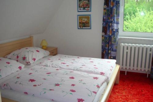 ein Schlafzimmer mit einem weißen Bett mit Blumen darauf in der Unterkunft Ferienwohnung Mattke in Heiligendamm