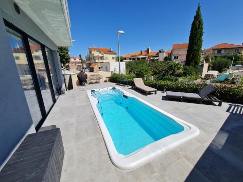 a swimming pool on a patio next to a house at SPA Apartment Vito in Vodice