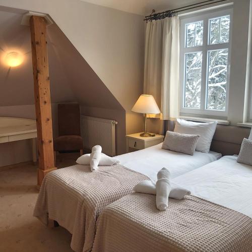 two beds with teddy bears on them in a bedroom at Villa Lessing in Polanica-Zdrój