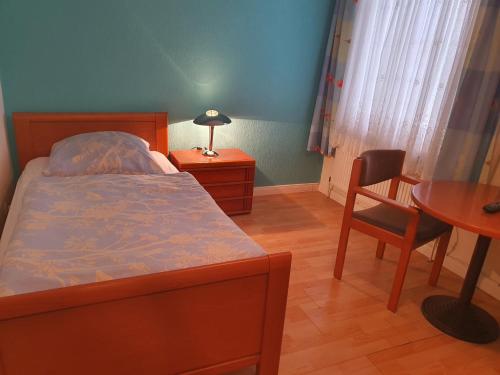 Schlafzimmer mit einem Bett, einem Schreibtisch und einem Tisch in der Unterkunft Hotel Busch in Wilster in Wilster
