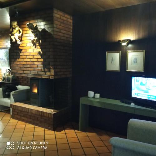a living room with a fireplace and a tv at Hotel Senhora A Branca in Braga