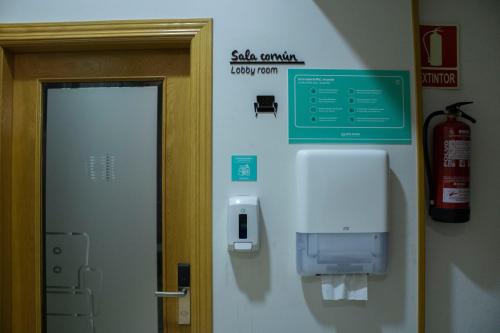 a bathroom with a soap dispenser on the wall at Hotel Alda Estación Oviedo in Oviedo