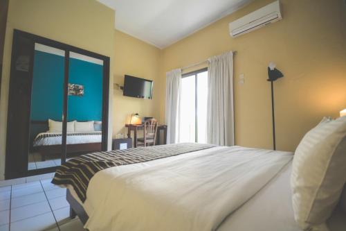 a bedroom with a large white bed and a window at Ganalé Hôtel in Dakar