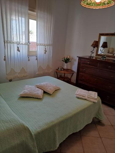 una camera con un letto con due cuscini sopra di La casa del mare a Cava dʼAliga