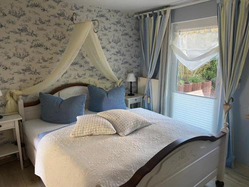 a bedroom with a bed with a canopy and a window at Gästehaus Schmidt in Boltenhagen