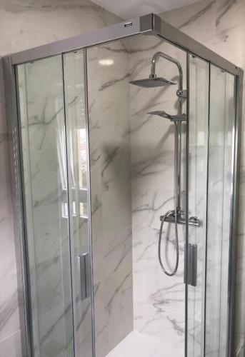 a shower with a glass door in a bathroom at Apartamentos Corcubión in Corcubión