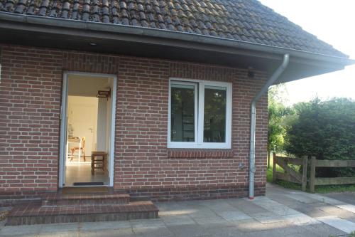 a brick house with a door and a window at Ferienwohnung Mühlenweg in Süderlügum