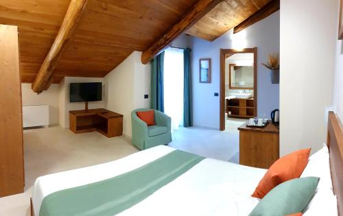 um quarto com uma cama, uma cadeira e uma televisão em Agriturismo La Desiderata em Agliè