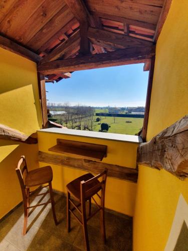 a room with a large window with two chairs and a table at Agriturismo La Desiderata in Agliè