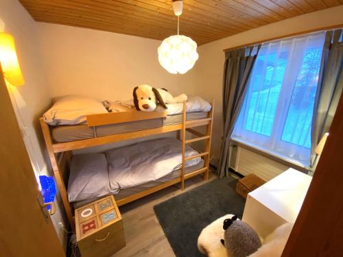a bedroom with bunk beds with a panda bear on them at Haus Trynsch Flumserberg in Flumserberg