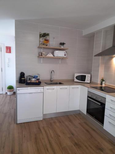 a kitchen with white cabinets and a sink at Los Palomitos, Casco Histórico VT-47255-V in Gandía