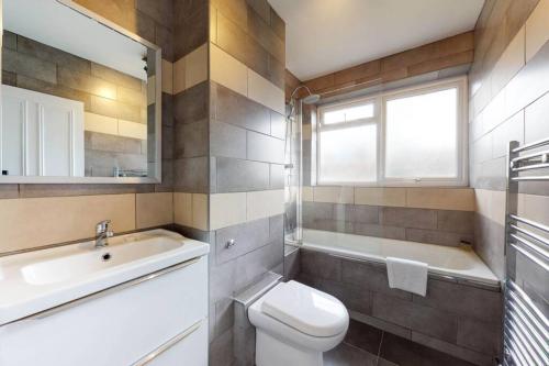 ein Badezimmer mit einem WC, einem Waschbecken und einer Badewanne in der Unterkunft Amazing 3 Bedroom Flat - 4mins to tube station in London