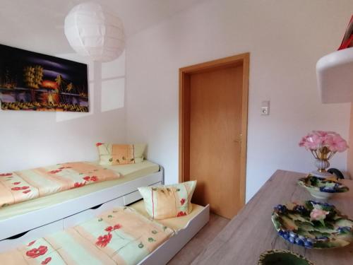 Habitación pequeña con 2 camas y mesa. en Ferienwohnung Rosenblick, en Bad Langensalza