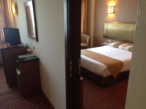 a hotel room with a bed and a television at Hotel Artiç in Bursa