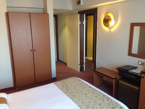 a bedroom with a bed and a dresser and a mirror at Hotel Artiç in Bursa
