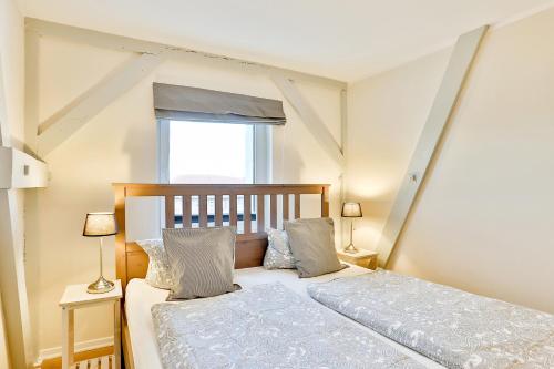 1 dormitorio con 1 cama con 2 lámparas y una ventana en Apartmenthaus Tribseer Damm 6 en Stralsund
